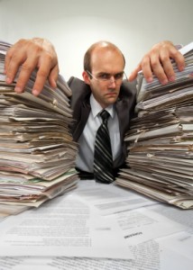 Businessman with big piles of paperwork